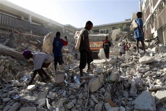 Youths search the rubble of a collapsed building for anything they can reuse or sell in the aftermath of Haiti's earthquake in Port-au-Prince, Tuesday, Feb. 9.